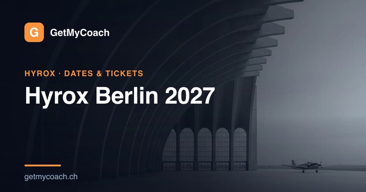 The vast curved concrete canopy of a historic 1930s airport terminal seen from inside, a wide empty apron running away toward tall arched openings and a single small propeller aircraft parked far off in grey daylight — cover image for the GetMyCoach guide to Hyrox Berlin 2027.