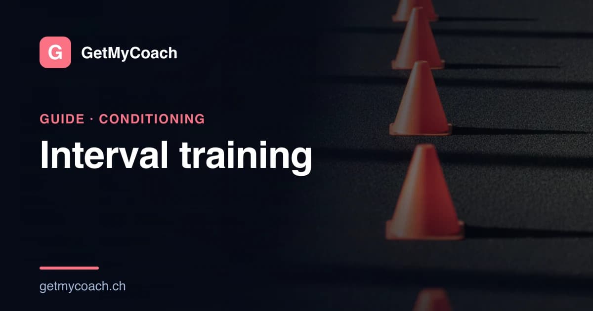 Training cones set at even intervals down a dark indoor sprint lane, each one picked out by an overhead light.